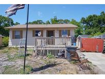 Charming single-story home with a cozy front porch and well-lit exterior, perfect for relaxing outdoors at 6812 E 21St Ave, Tampa, FL 33619