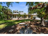 Beautiful home featuring a large, landscaped front yard and inviting wrap-around porch at 710 N River Rd, Venice, FL 34293
