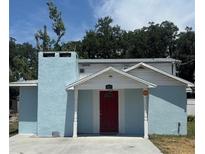 Charming light blue single-story home with a red door and white trim around the entryway, chimney, and roof at 816 Drane Nw St, Plant City, FL 33563
