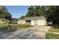 Charming single-story home featuring a well-manicured lawn, a driveway, and an attached garage in a quiet neighborhood at 834 Anchorage Ln, Palm Harbor, FL 34685