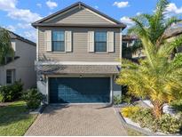 Charming two-story home with a blue garage door and well-maintained landscaping at 10005 Sage Creek Dr, Ruskin, FL 33573