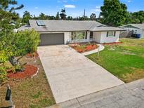 Charming single-story home featuring a well-maintained lawn, gray garage door, and nicely landscaped front yard at 1002 Fruitland Ave, Bradenton, FL 34207