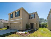 Beautiful two-story home with a two-car garage, an inviting front porch and manicured landscaping at 16810 Trite Bend St, Wimauma, FL 33598