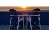 Outdoor seating for two on the rooftop deck with serene water view at 228 Shore Dr, Tarpon Springs, FL 34689