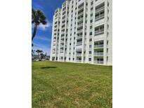 Waterfront condo building featuring multiple balconies and lush green lawn at 400 64Th Ave # 202, St Pete Beach, FL 33706