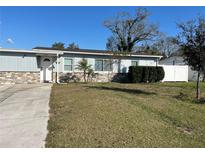 Charming single-story home with a stone accent wall and well-maintained lawn at 7503 N Howard Ave, Tampa, FL 33604