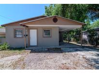 Single-story home featuring a tan exterior, a covered carport, and a white front door at 907 Tyner St, Plant City, FL 33563