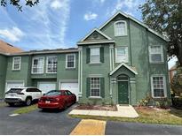Charming townhome with green exterior, well-maintained landscaping, and private parking spaces at 9650 Lake Chase Island Way # 9650, Tampa, FL 33626