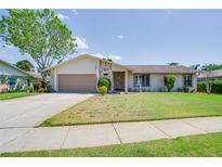Charming single-story home with stone accents, a well-manicured lawn and an attached two car garage at 1104 Northridge Dr, Palm Harbor, FL 34683