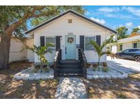 Charming home featuring a welcoming front porch with dark shutters and a cheerful pastel door at 1110 36Th N Ave, St Petersburg, FL 33704