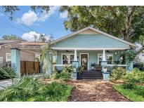 Charming home with a welcoming front porch and lush landscaping at 1207 E Giddens Ave, Tampa, FL 33603