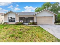Charming single-story home with a front porch, two-car garage and well-maintained lawn in a quiet neighborhood at 1218 Gillespie N Dr, Palm Harbor, FL 34684