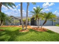 Beautiful home boasts mature landscaping, creating a welcoming curb appeal, with a covered entry at 1805 Stable Trl, Palm Harbor, FL 34685
