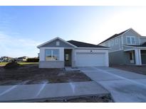 Charming single-story home featuring stone accents, a two-car garage, and a well-manicured lawn at 6270 Broad Field Ave, Apollo Beach, FL 33572