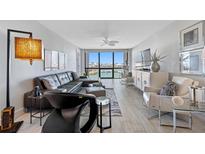 Modern living room featuring a waterfront view, comfortable seating, and stylish decor at 1 Key Capri # 211W, Treasure Island, FL 33706