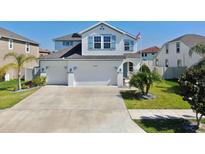 Charming two-story home featuring a three-car garage, landscaped yard, and crisp white exterior at 11625 Tetrafin Dr, Riverview, FL 33579