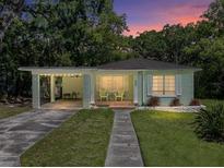 Charming single-story home with a carport, front porch with chairs, and well-maintained lawn at sunset at 131 Oak Park Ave, Brooksville, FL 34601