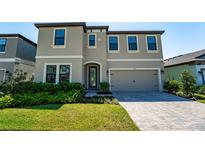 Charming two-story home features a paver driveway, manicured lawn, and attached two-car garage at 14623 Horse Trot Rd, Lithia, FL 33547