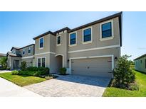 Charming two-story home with brick driveway, a two-car garage, and well-manicured landscaping at 14623 Horse Trot Rd, Lithia, FL 33547