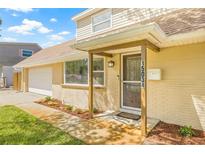 Charming home showcasing a well-manicured lawn and front porch, plus a spacious two-car garage at 15034 Newport Rd, Clearwater, FL 33764