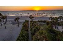 Beautiful sunset view of the beach with palm trees and white sand at 1581 Gulf Blvd # 301N, Clearwater Beach, FL 33767