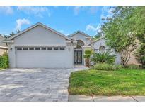 Charming single-story home featuring manicured landscaping and a spacious two-car garage, enhancing its curb appeal at 18836 Maisons Dr, Lutz, FL 33558