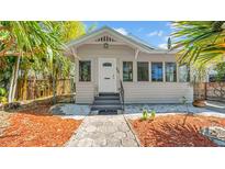 Charming home featuring a white door, decorative front windows, and inviting stone walkway surrounded by lush, tropical landscaping at 220 19Th S Ave, St Petersburg, FL 33705
