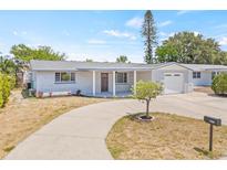 Charming single-story home featuring a covered entrance, attached garage, and meticulously maintained landscaping at 2616 Ohio Pl, Holiday, FL 34691