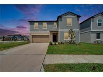 Charming two-story home with a well-maintained lawn and attached two-car garage at 34780 Rainville Loop, Zephyrhills, FL 33541