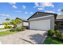 Inviting home features a lush, manicured lawn and a pristine two-car garage with paver driveway at 3764 Laughing Dove Ave, Sun City Center, FL 33573