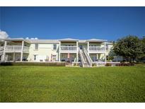 Exterior view of multiple townhomes, showcasing their balconies, patios, and well-maintained lawn at 4816 Snook Se Dr # F, St Petersburg, FL 33705