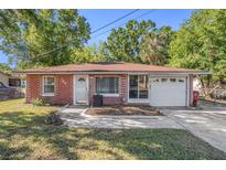 Charming brick home featuring a well-kept front yard and an attached single-car garage at 705 E Alabama St, Plant City, FL 33563