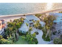 Stunning beachfront home boasts lush landscaping, a circular driveway, and breathtaking ocean views at 770 N Manasota Key Rd, Englewood, FL 34223