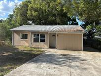 Inviting one story home featuring a concrete driveway and metal roof at 1106 Woodlawn Ave, Plant City, FL 33563