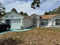 Charming single-story home with a well-maintained lawn, attached garage, and neutral paint scheme at 12447 Drysdale St, Spring Hill, FL 34609