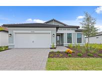 Charming single-story home with a two-car garage, landscaped yard, and a welcoming front entrance at 17200 Luminous Ave, Venice, FL 34293