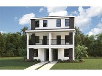 Modern two-story home featuring a sleek design, balcony, and well-manicured lawn at 1922 W Fig St # 2, Tampa, FL 33609