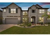 Beautiful two-story home with stone accents, a well-manicured lawn, and a two-car garage at 19316 Eagle Creek Ln, Tampa, FL 33647
