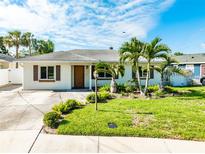 Charming single-story home with a well-manicured lawn, palm trees and a welcoming front entrance at 4104 W Watrous Ave, Tampa, FL 33629