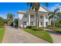 Elegant two-story home featuring a classic facade with stately columns and mature palm trees at 4935 W Bay Way Pl, Tampa, FL 33629