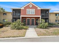 Charming condo with terra cotta exterior, well-kept landscaping, and screened in porch on both levels at 5636 Baywater Dr # 5636, Tampa, FL 33615