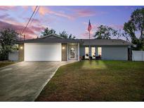 Charming single-story home with a well-manicured lawn and an American flag at 10115 Kenlake Dr, Riverview, FL 33578