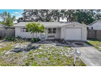 Charming single-story home featuring a well-maintained lawn and attached one car garage at 1408 Maybury Dr, Holiday, FL 34691