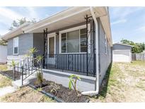 Charming home's front porch features decorative black iron railings, enhancing curb appeal at 3253 57Th N Ave, St Petersburg, FL 33714