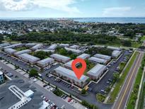 Real estate aerial view featuring condo community, lush landscaping, and water views at 3815 35Th S Way # 102, St Petersburg, FL 33711