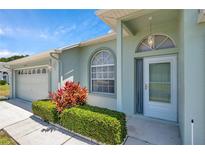 Charming front entrance with well-maintained landscaping, arched window and a light-colored exterior at 4301 Avanti Cir, New Port Richey, FL 34655