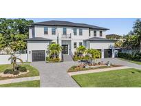 Beautiful two-story home with lush landscaping, paver driveway, and two-car garage at 481 W Davis Blvd, Tampa, FL 33606