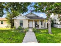 Charming single-story home featuring a covered porch and lush front yard landscaping at 718 30Th N Ave, St Petersburg, FL 33704