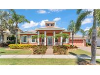 Charming coral home features manicured landscaping, vibrant yellow shrubs, and elegant white pillars framing the entrance at 729 Manns Harbor Drive, Apollo Beach, FL 33572