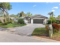Charming single-story home featuring a manicured lawn, mature trees, and a two-car garage at 1004 Hollyberry Ct, Brandon, FL 33511